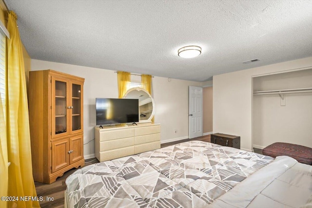 bedroom featuring wood-type flooring, a textured ceiling, and a closet