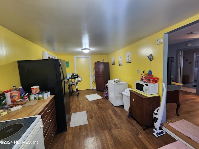 kitchen with white appliances, dark hardwood / wood-style floors, and dark brown cabinetry