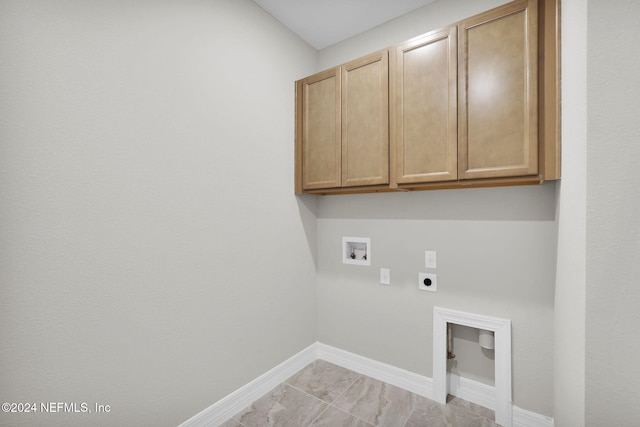 washroom featuring hookup for an electric dryer, hookup for a washing machine, and cabinets