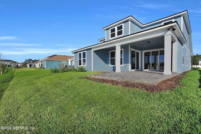 back of house with a lawn and a patio