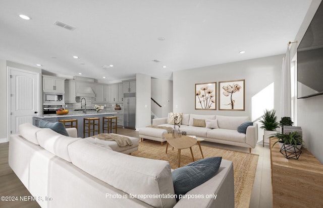 living room with light hardwood / wood-style flooring and sink