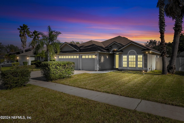 view of front of home with a lawn, a garage, and french doors