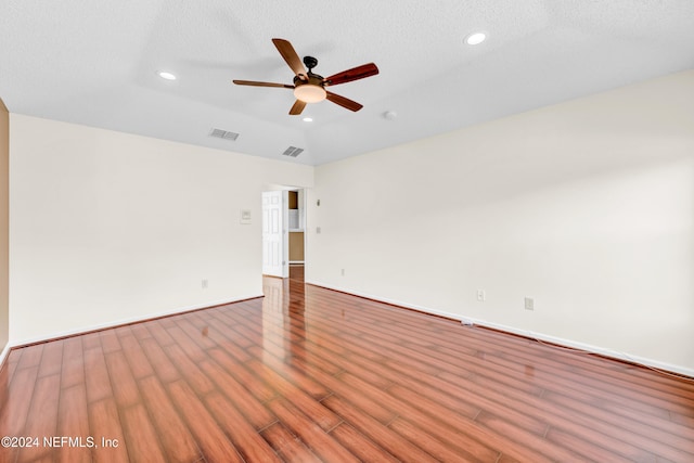 spare room featuring wood-type flooring, a textured ceiling, ceiling fan, and lofted ceiling