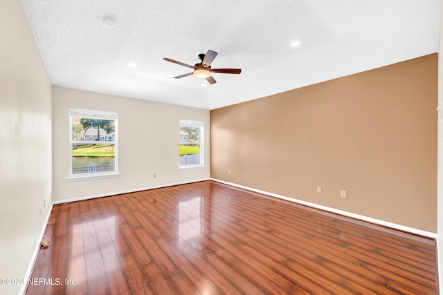 empty room with hardwood / wood-style floors, ceiling fan, and a textured ceiling