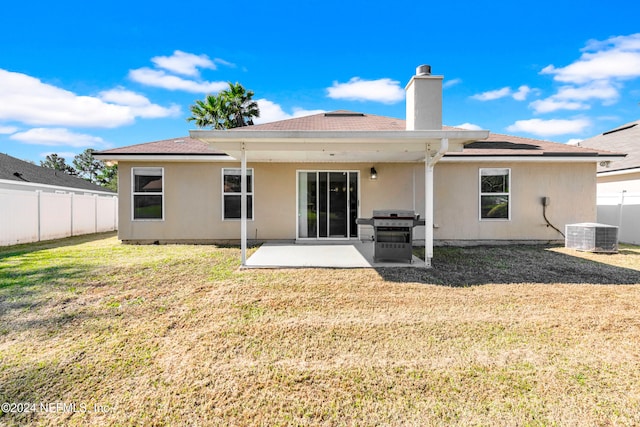 rear view of house featuring a lawn, a patio area, and central air condition unit