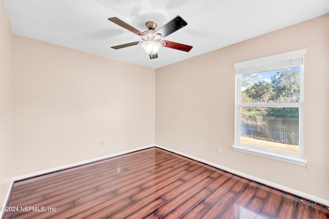 spare room with wood-type flooring, a textured ceiling, and ceiling fan