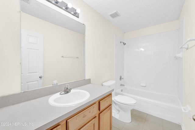 full bathroom featuring vanity, tile patterned floors, tiled shower / bath combo, toilet, and a textured ceiling