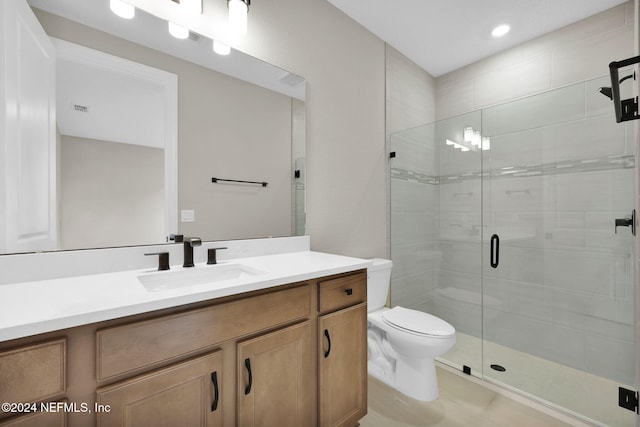 bathroom featuring vanity, toilet, and a shower with door