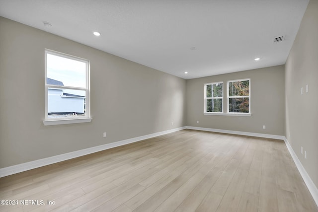 unfurnished room featuring plenty of natural light and light hardwood / wood-style floors