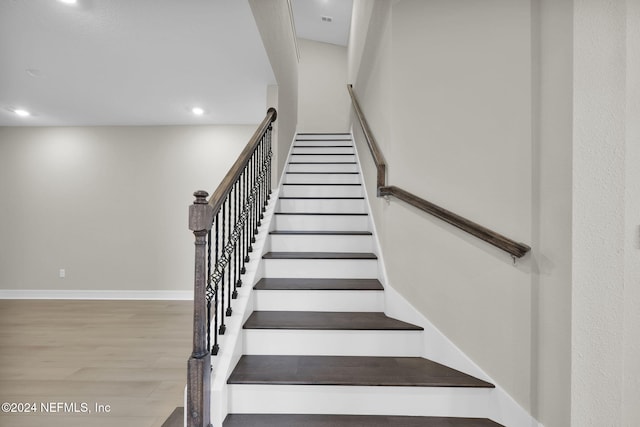 staircase with hardwood / wood-style floors