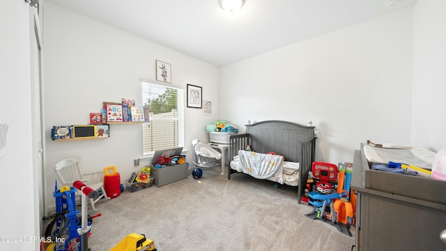 bedroom featuring light carpet and a crib