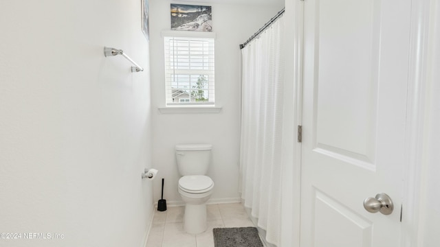 bathroom featuring tile patterned flooring, a shower with curtain, and toilet