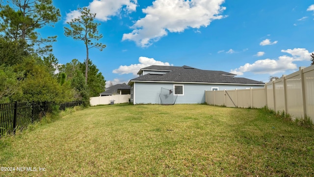 rear view of house featuring a lawn