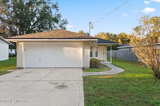 ranch-style home featuring a front lawn and a garage