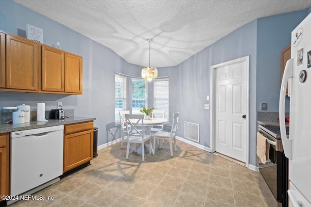 kitchen with a textured ceiling, decorative light fixtures, white appliances, and an inviting chandelier