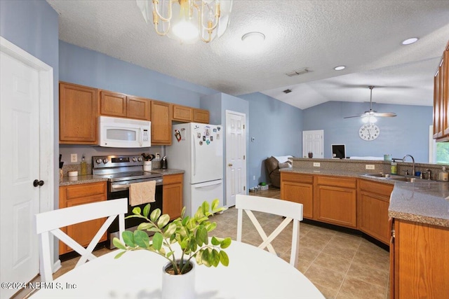 kitchen with lofted ceiling, white appliances, ceiling fan with notable chandelier, sink, and kitchen peninsula