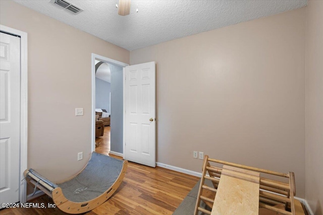 office area with hardwood / wood-style floors, ceiling fan, and a textured ceiling