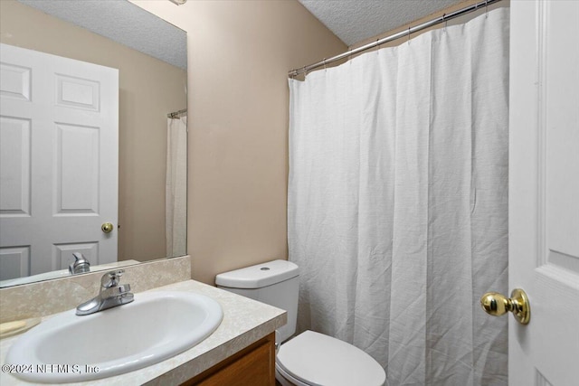 bathroom featuring vanity, a textured ceiling, and toilet