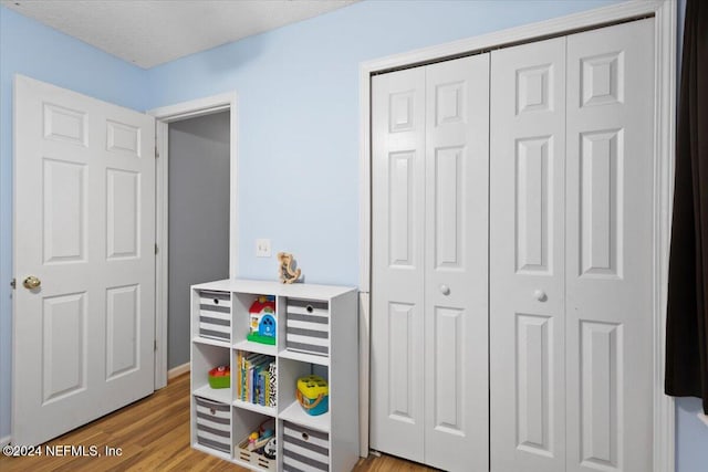 rec room with a textured ceiling and light wood-type flooring