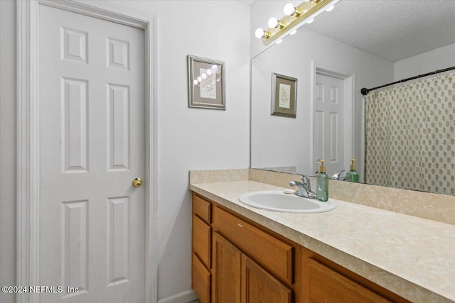 bathroom with vanity, a textured ceiling, and a shower with shower curtain