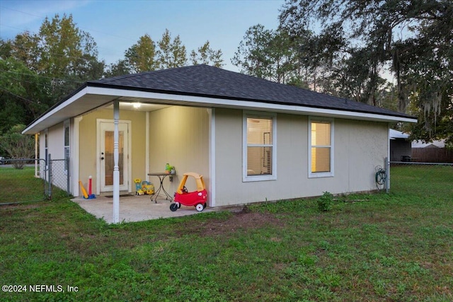 back of property featuring a patio area and a yard