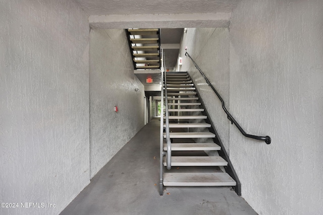 stairs with concrete flooring