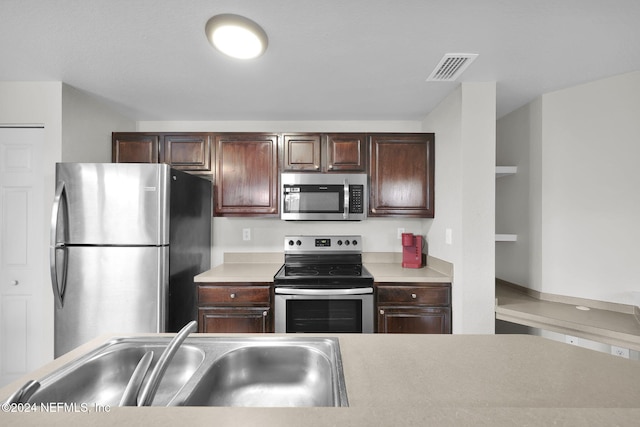 kitchen featuring dark brown cabinets, stainless steel appliances, and sink