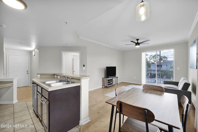 kitchen with dark brown cabinetry, dishwasher, sink, decorative light fixtures, and light wood-type flooring