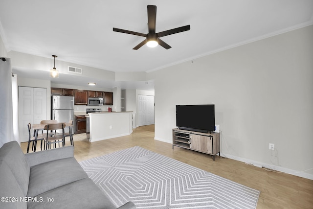 living room with ceiling fan, ornamental molding, and light wood-type flooring