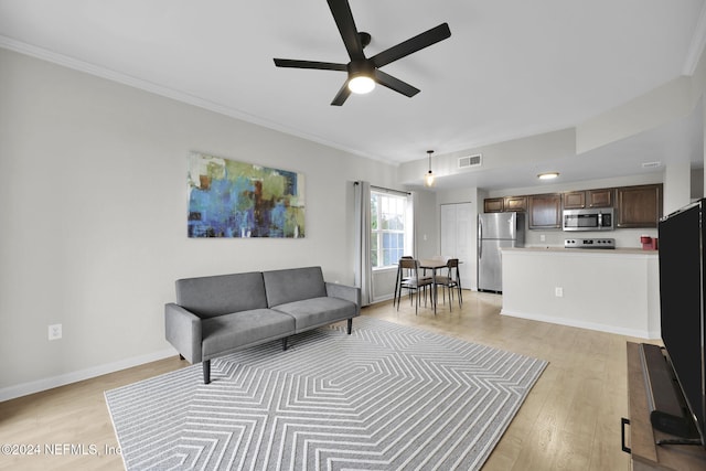 living room featuring ceiling fan, light hardwood / wood-style floors, and crown molding