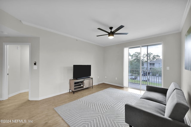 living room featuring ceiling fan, ornamental molding, and light wood-type flooring