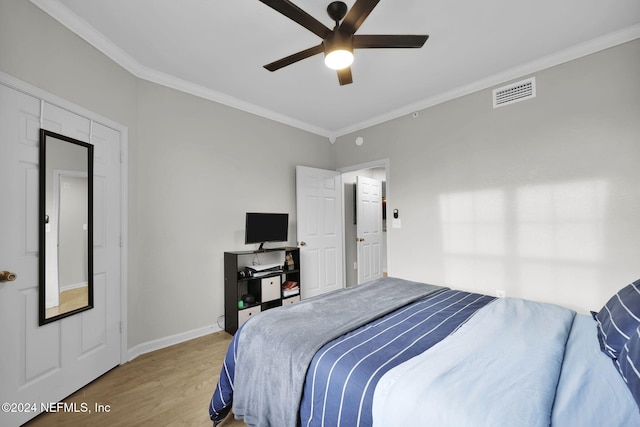 bedroom with hardwood / wood-style floors, ceiling fan, and crown molding