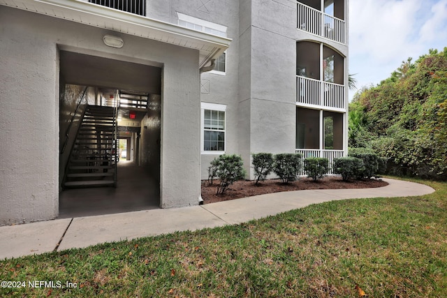 entrance to property featuring a lawn