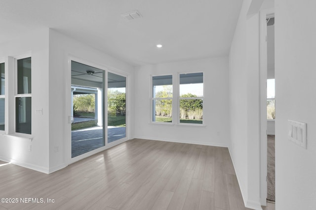 unfurnished room featuring recessed lighting, wood finished floors, visible vents, and baseboards