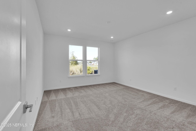 empty room featuring carpet flooring, recessed lighting, and baseboards