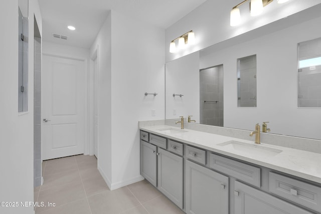 full bathroom with tile patterned flooring, visible vents, double vanity, and a sink