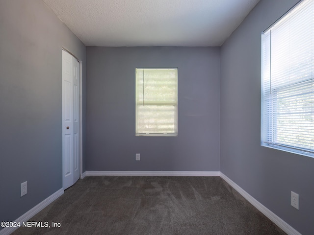 carpeted empty room with a textured ceiling