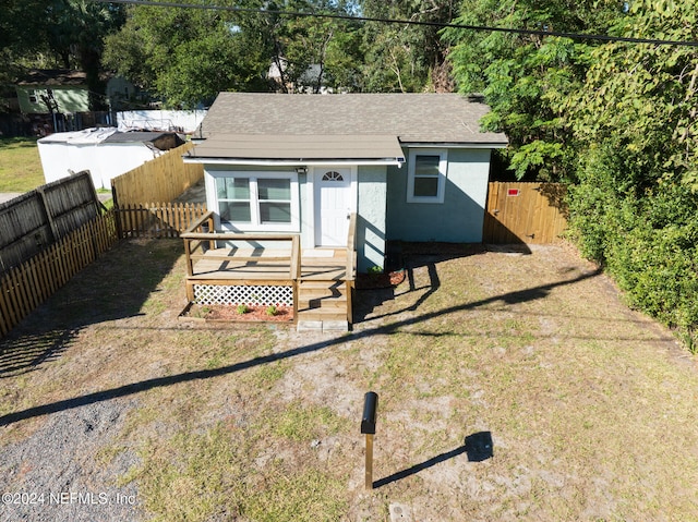 bungalow-style house featuring a wooden deck and a front yard