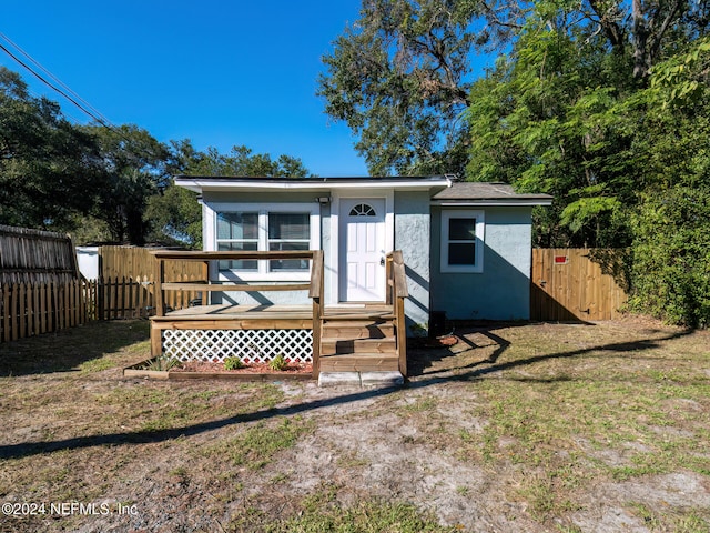 view of front of home featuring a wooden deck and a front lawn