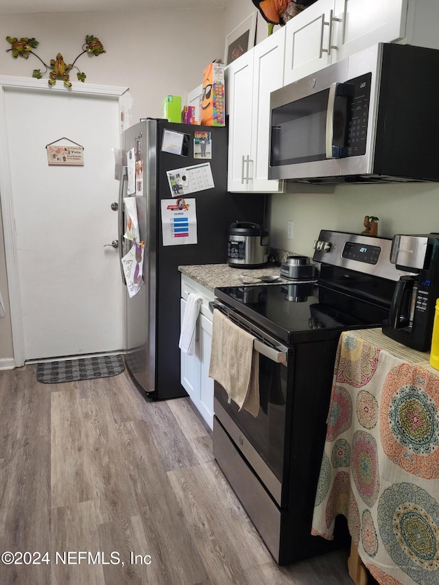 kitchen with white cabinetry, light hardwood / wood-style floors, and appliances with stainless steel finishes