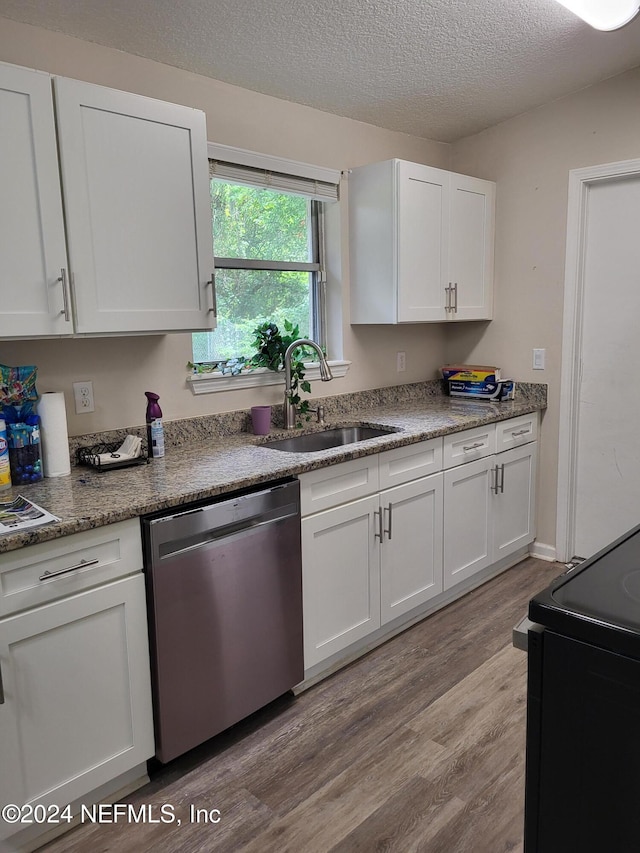 kitchen featuring electric stove, sink, stainless steel dishwasher, light wood-type flooring, and white cabinetry