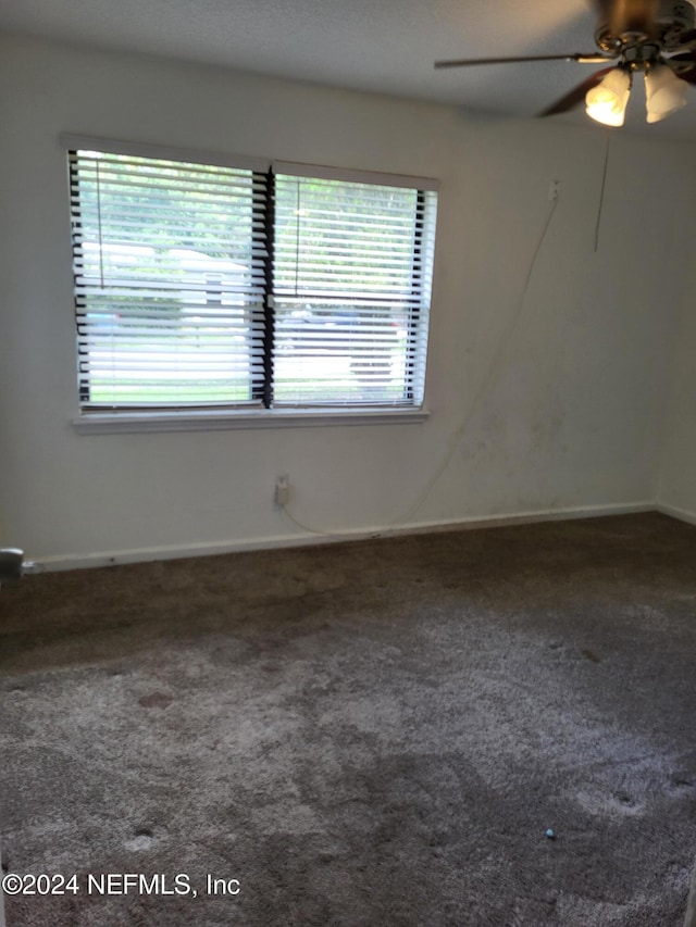 carpeted spare room featuring ceiling fan