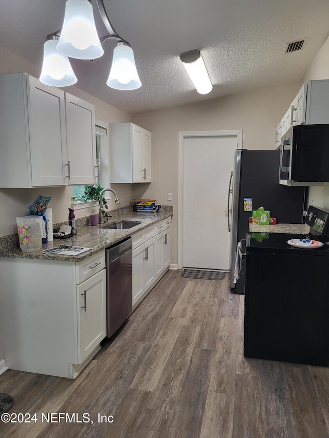 kitchen with sink, hanging light fixtures, hardwood / wood-style flooring, appliances with stainless steel finishes, and white cabinetry