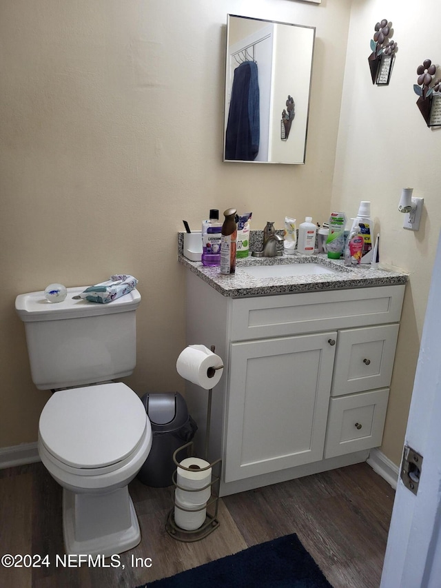 bathroom featuring vanity, wood-type flooring, and toilet