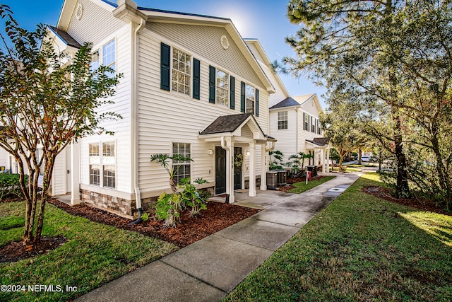 view of front facade with a front yard and central AC