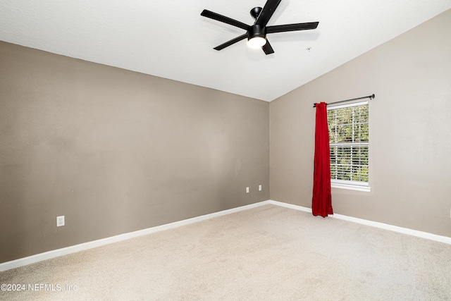 empty room featuring carpet flooring, ceiling fan, and vaulted ceiling