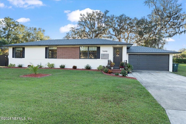 ranch-style home with a front yard and a garage