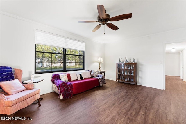 living room with dark hardwood / wood-style flooring, ceiling fan, and crown molding