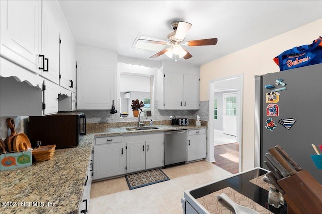 kitchen with ceiling fan, sink, light stone counters, white cabinets, and appliances with stainless steel finishes