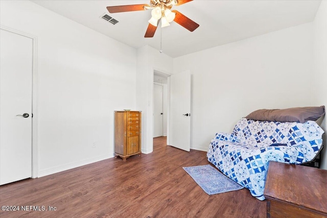 sitting room with ceiling fan and dark wood-type flooring